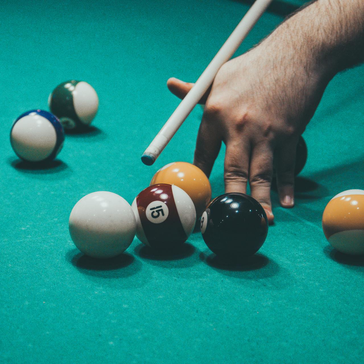 Close-up of a person playing pool, focusing on the cue and ball, symbolizing strategic decision-making and precision in business growth.